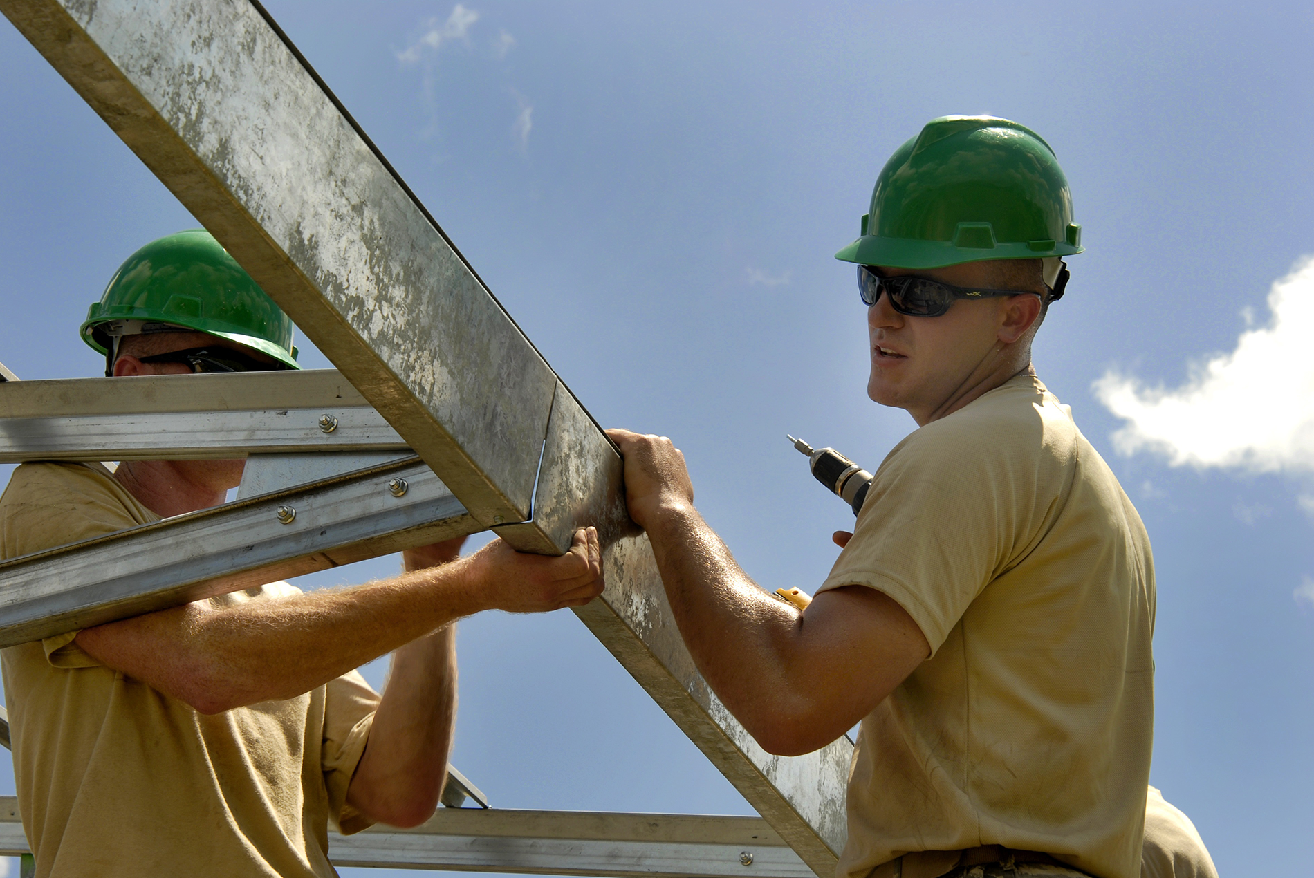 two men holding drills on a construction site